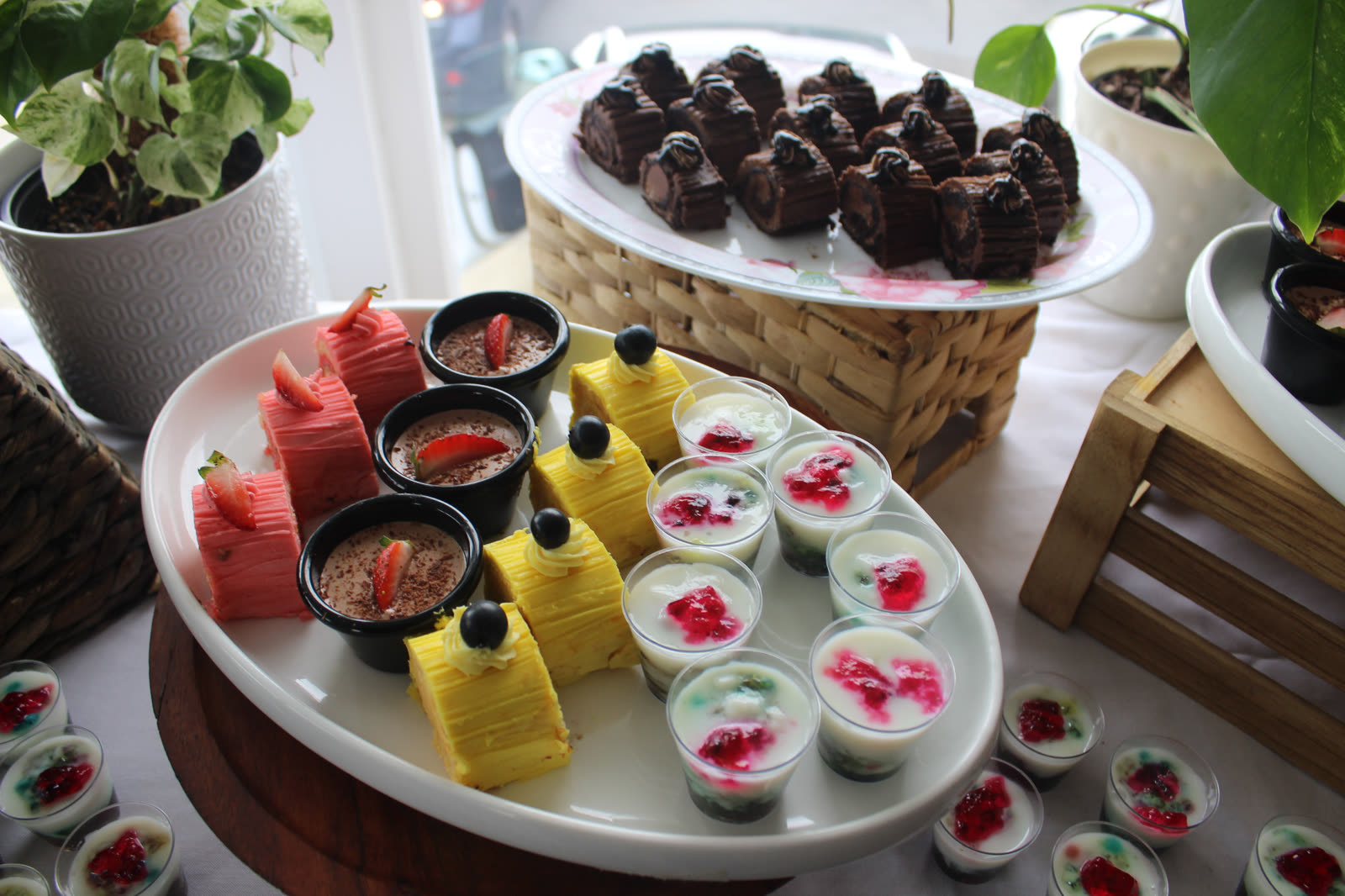 High tea dessert platter with pink ribbon cake, chocolate mousse cups, pineapple cake and falooda cups