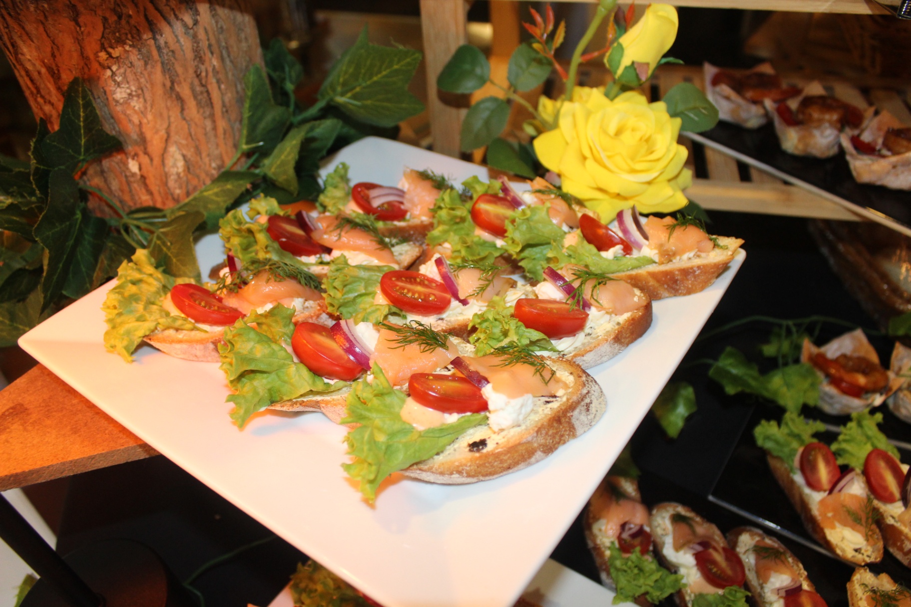 Smoked salmon crostini with cream cheese, dill and cherry tomatoes on a tiered stand