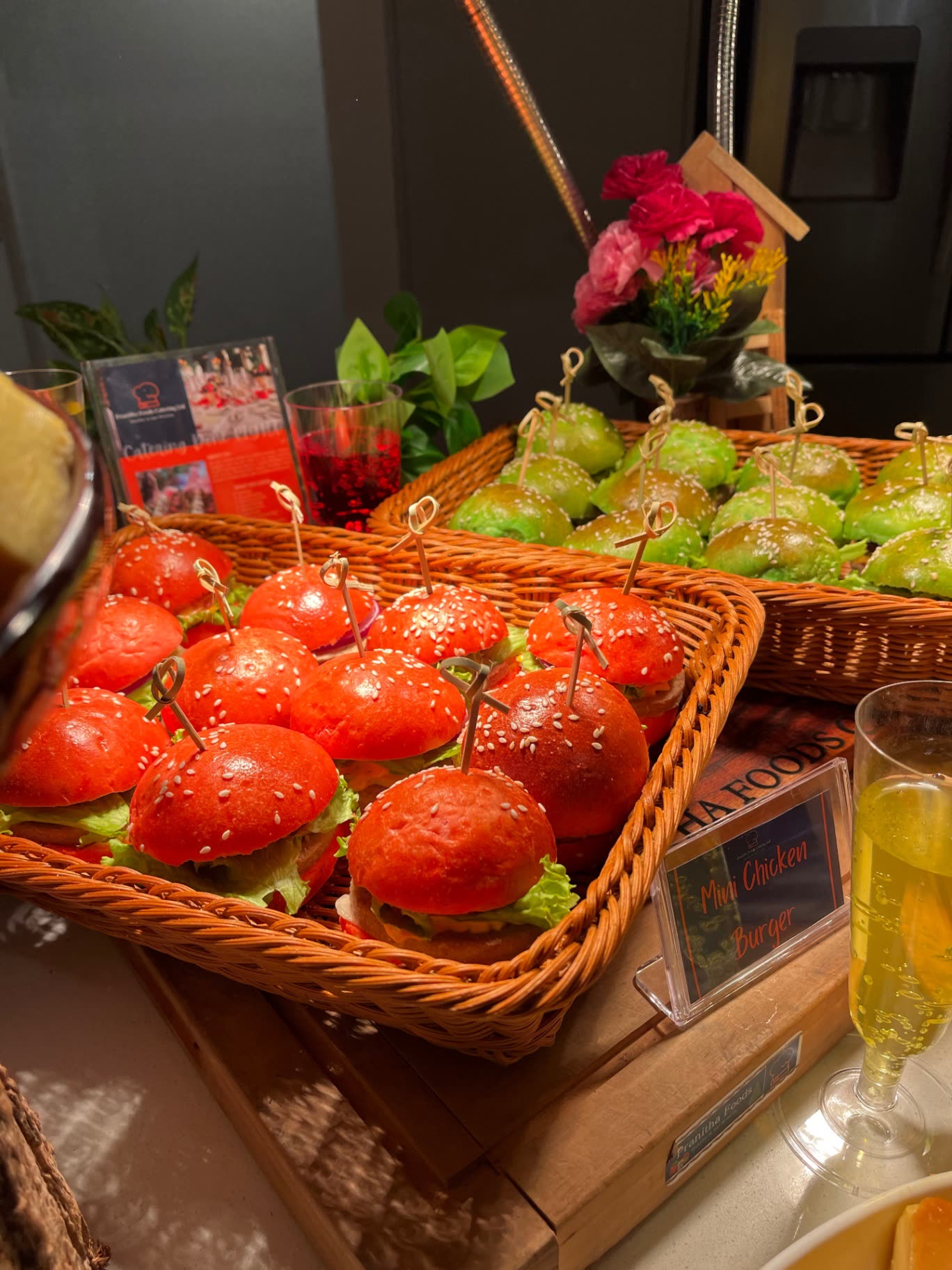 Mini chicken burgers with red and green brioche buns in wicker baskets